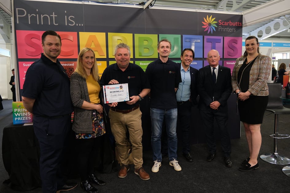 The Scarbutts' team standing in front of their award winning stand at Business Vision Live 2023